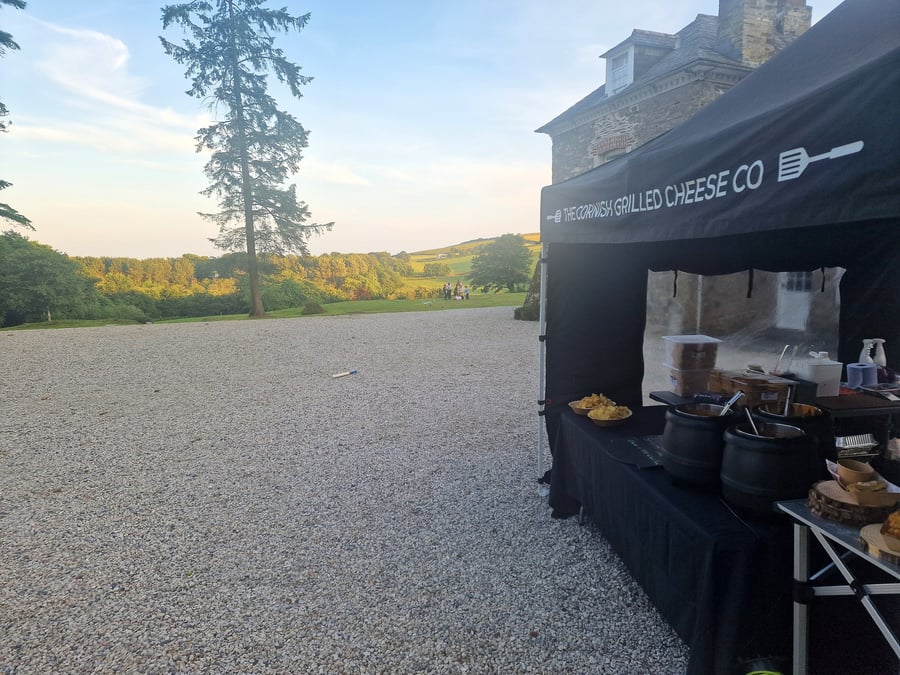 Outdoor food stall with catering tent set up in a scenic countryside location