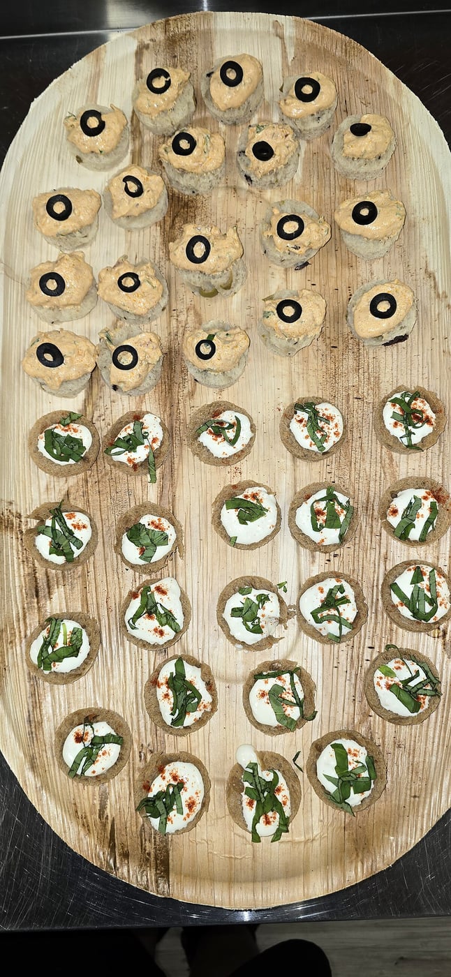 Two types of canapés arranged on a large wooden platter for an event