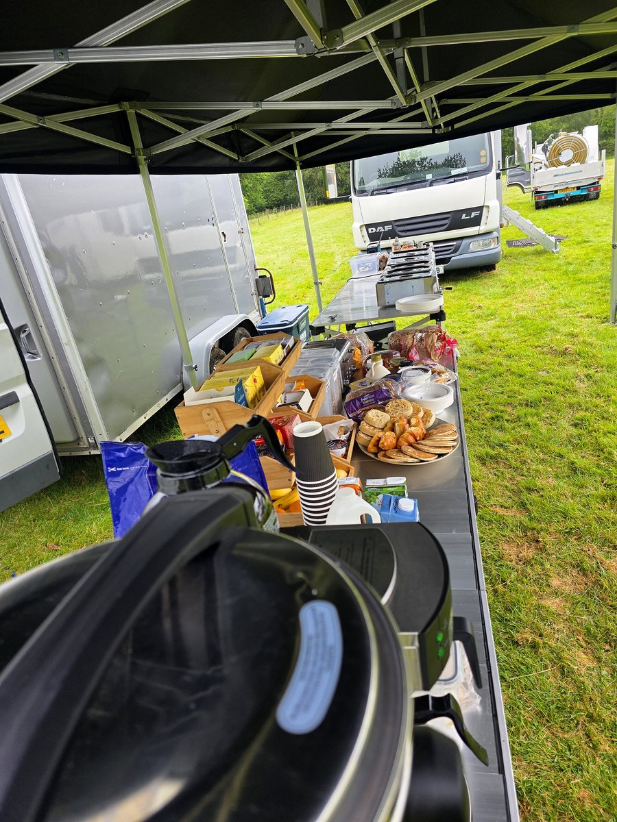 Outdoor catering setup with food and drinks laid out on a table