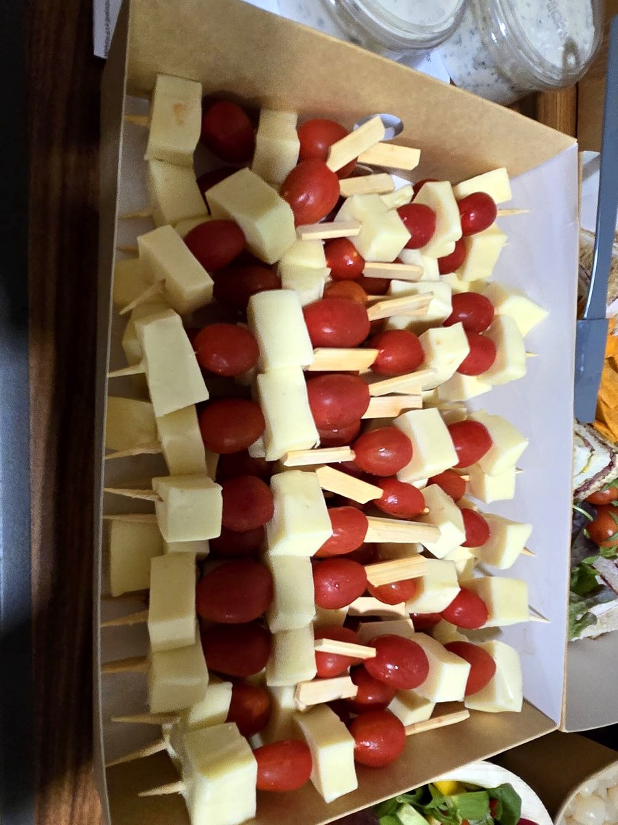 Skewers of cheese cubes and cherry tomatoes arranged in a cardboard box