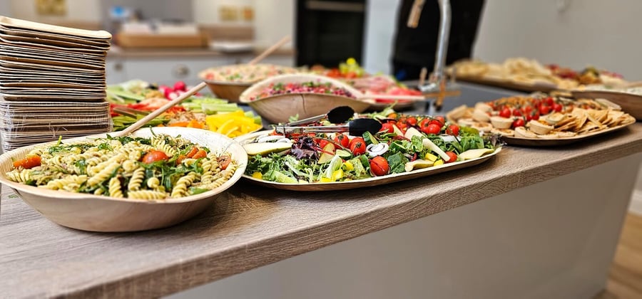 A spread of fresh salads, pasta, and appetizers laid out on a counter