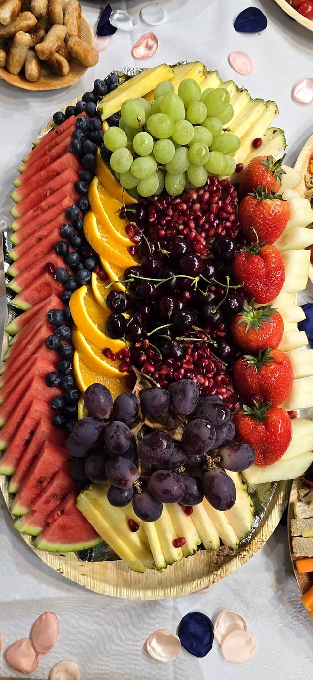 A vibrant platter overflowing with fresh, colourful fruits arranged artfully for an event