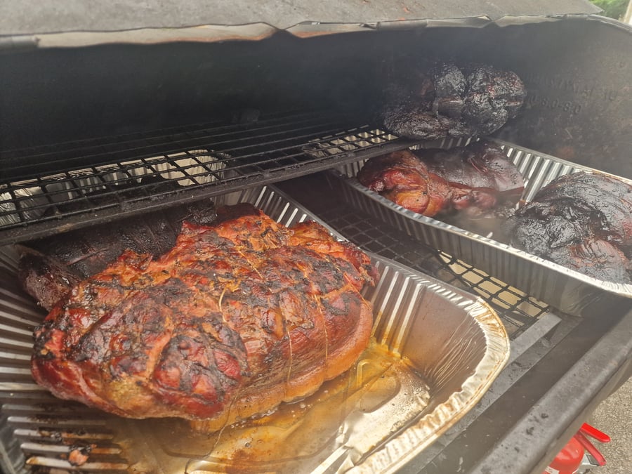 Succulent joints of meat slow-cooking in a smoker, ready for a delicious BBQ feast