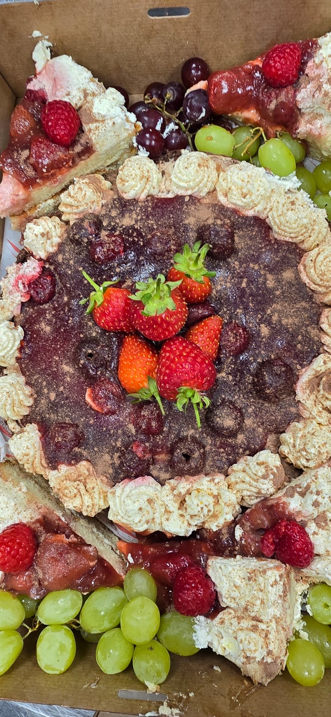 A close-up view of a delicious fruit tart topped with fresh strawberries and cream