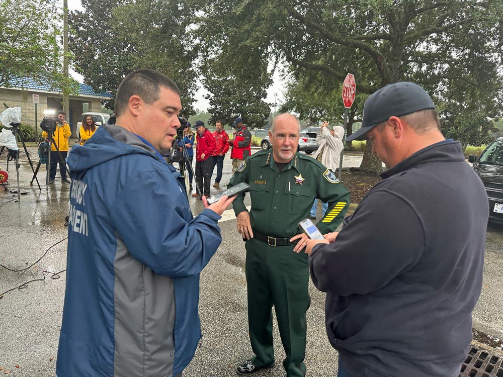 The tornado response's joint command this morning moments before a press conference at the Indian Trails Sports Complex, with, from left, Emergency Management Jonathan Lord, Sheriff Rock Staly and Palm Coast Fire Chief Kyle Berryhill. (© FlaglerLive)