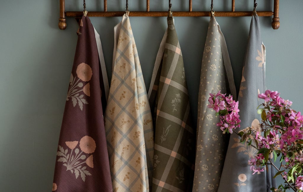 5 pieces of custom printed fabric hanging on a wall hook with designs printed by little cocalico on them