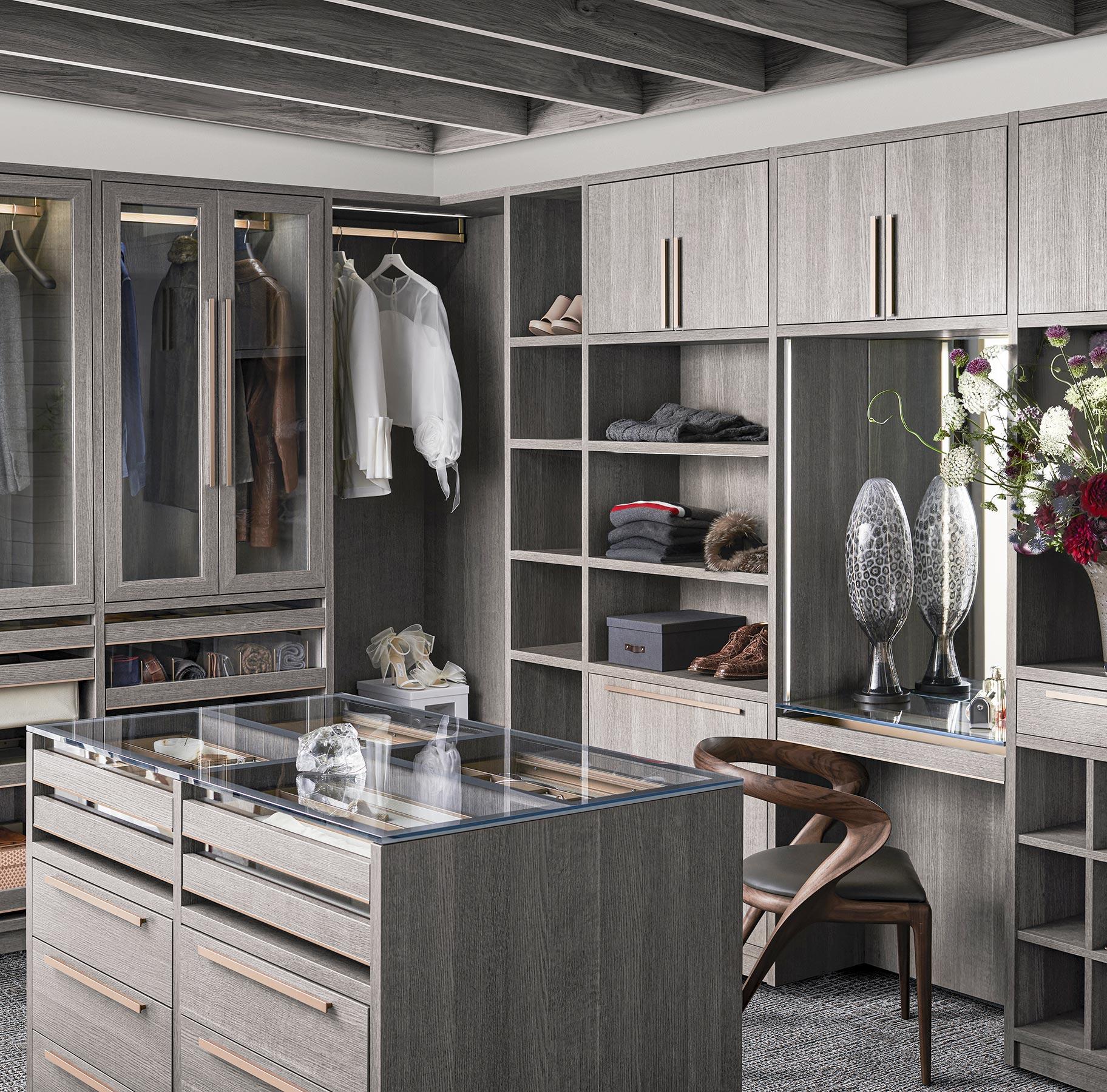 Modern layout walk in closet design with island storage and open shelves from California Closets