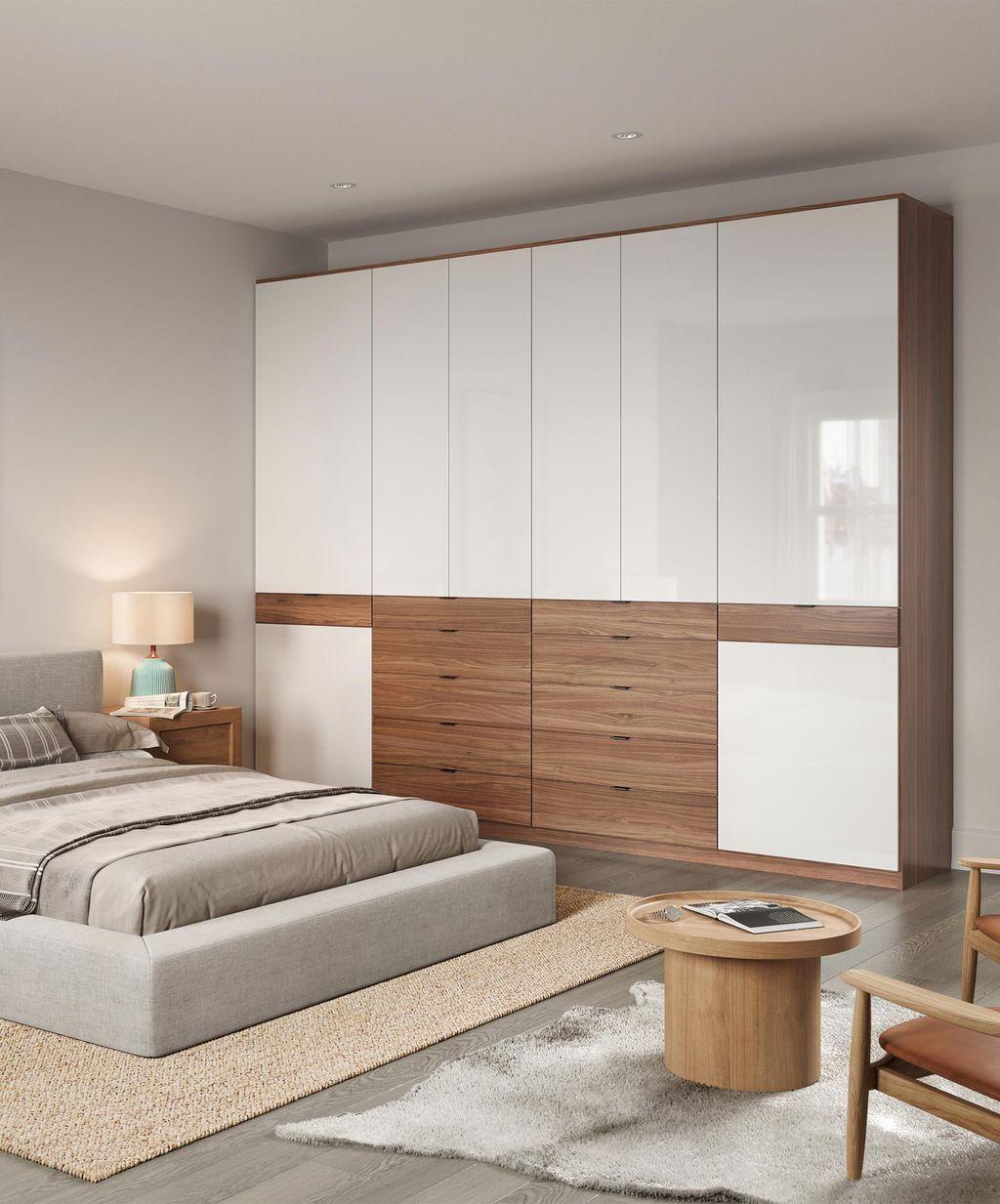 Custom closet built in wall, standing wardrobe in gloss and light wood grain finishes by California Closets