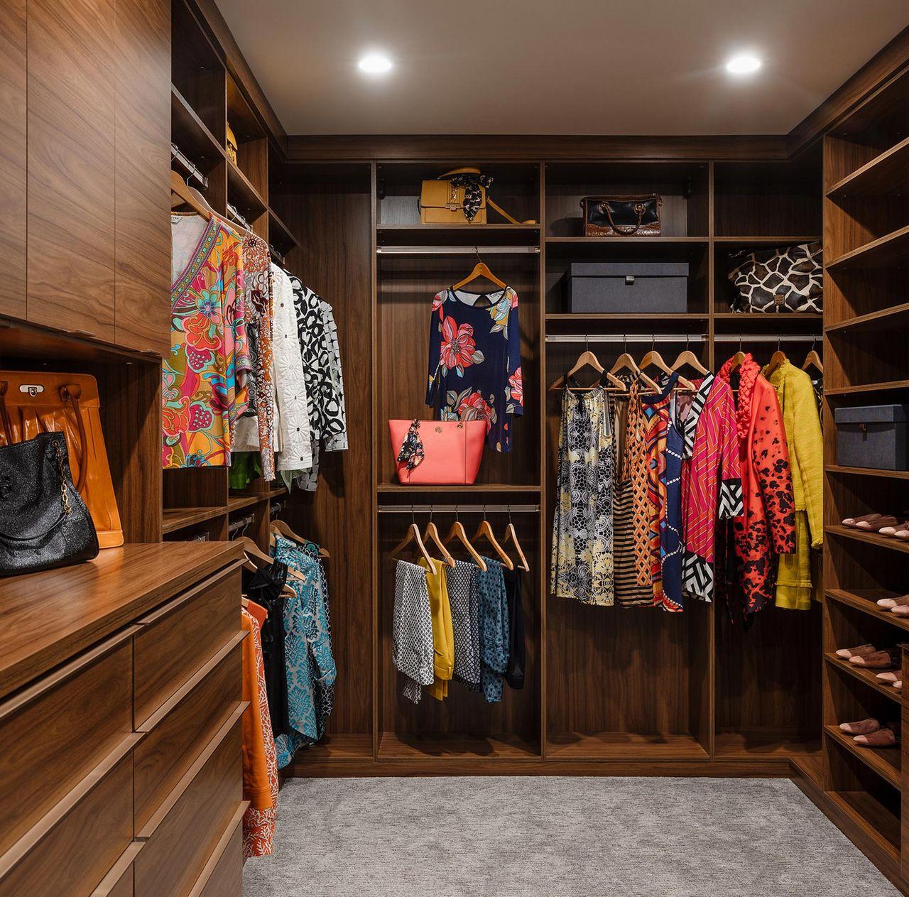 Custom closet in dark reddish brown wood grain finish with floor to ceiling storage by California Closets
