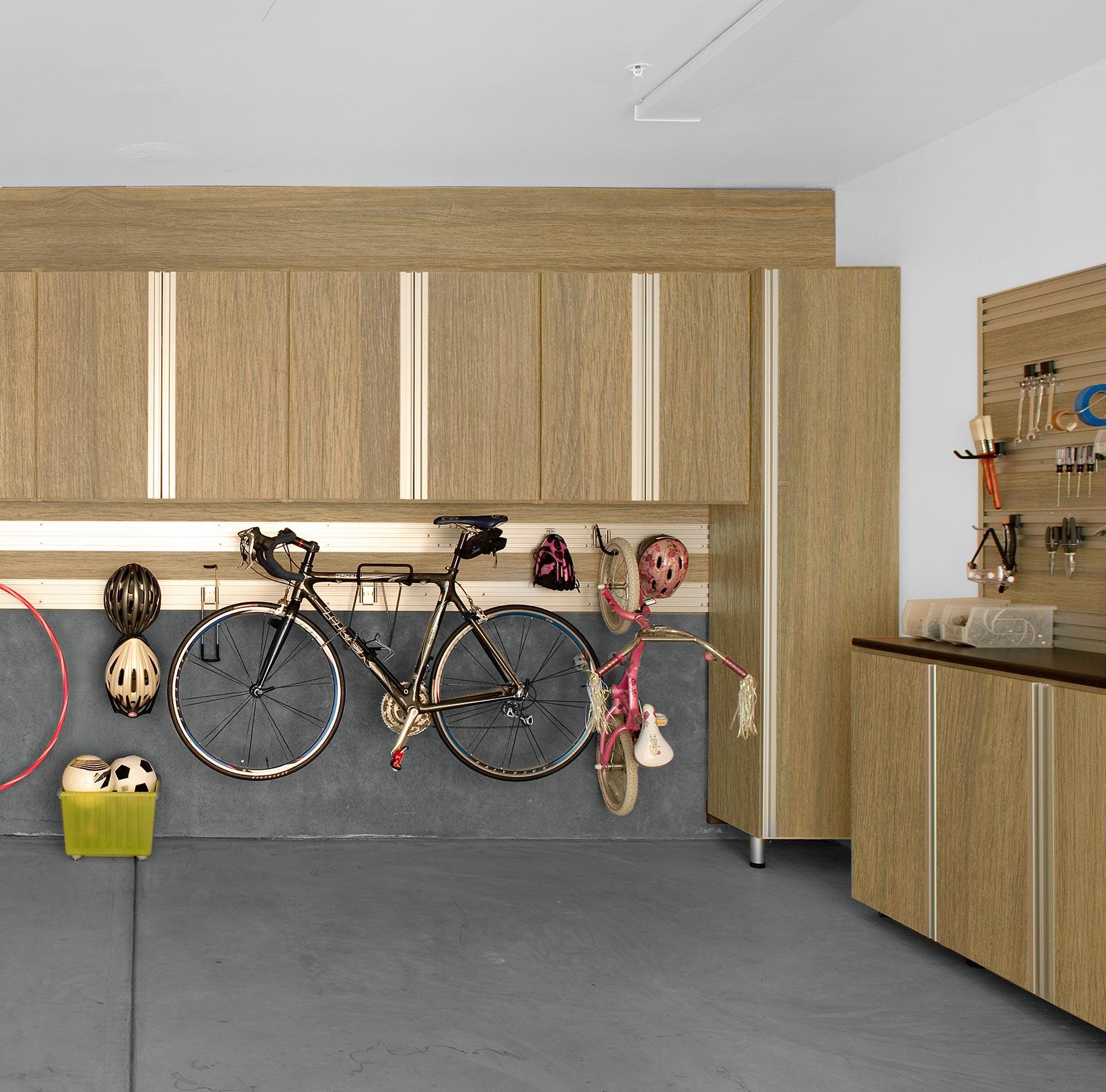 Custom-built garage cabinets with integrated workbench by California Closets