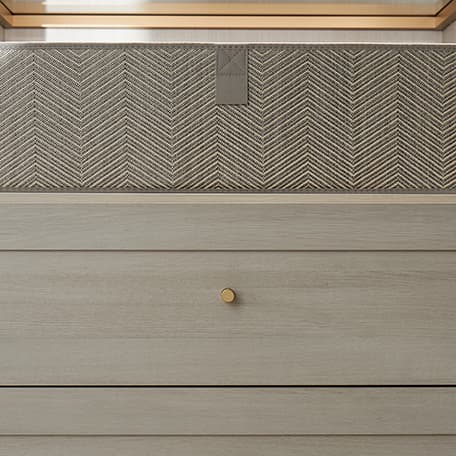 Custom drawers with decorative gold handles in dark finish with light finish counter by California Closets