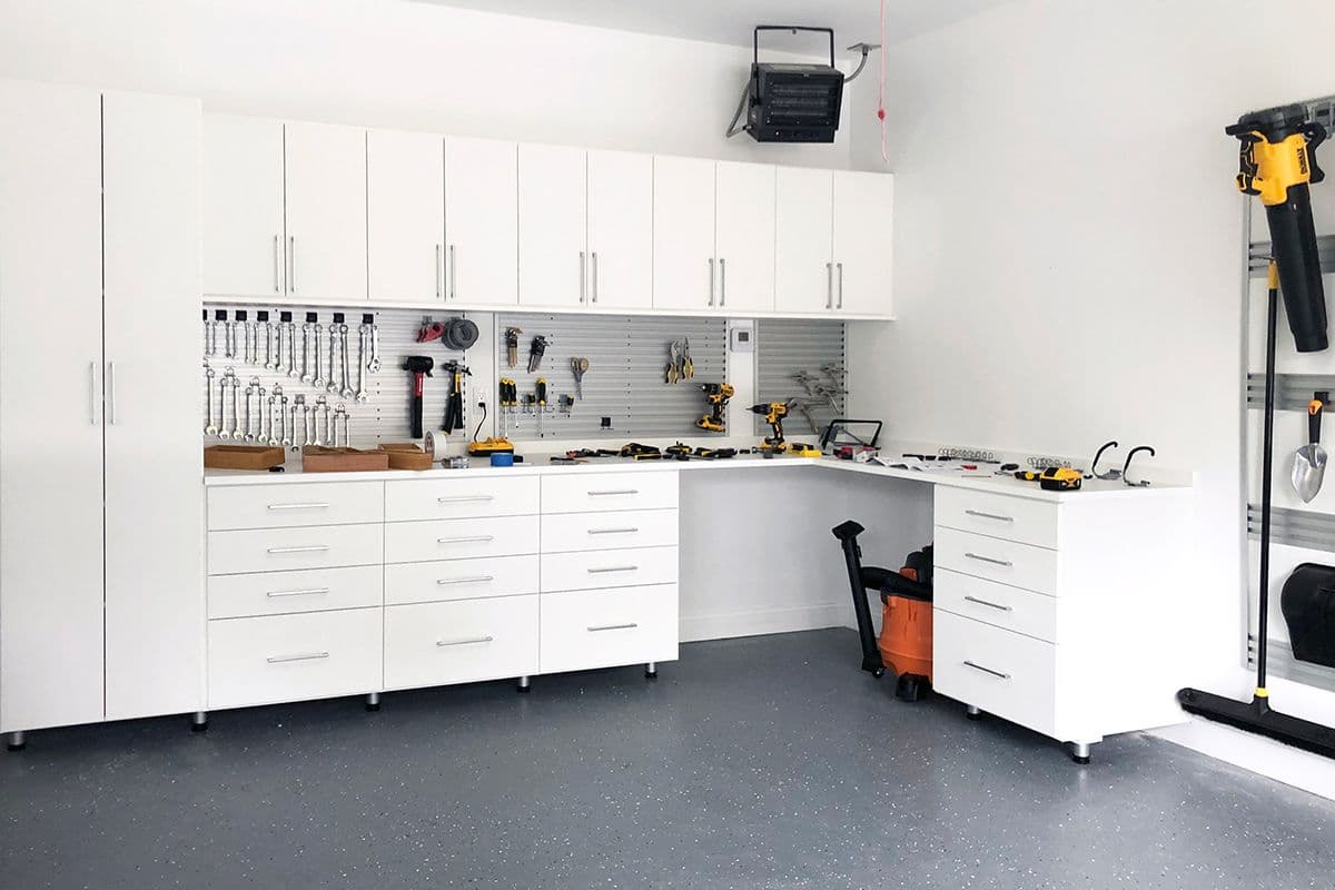 Custom storage cabinets and tool racks for garage system designed by California Closets. Activate to enhance image.