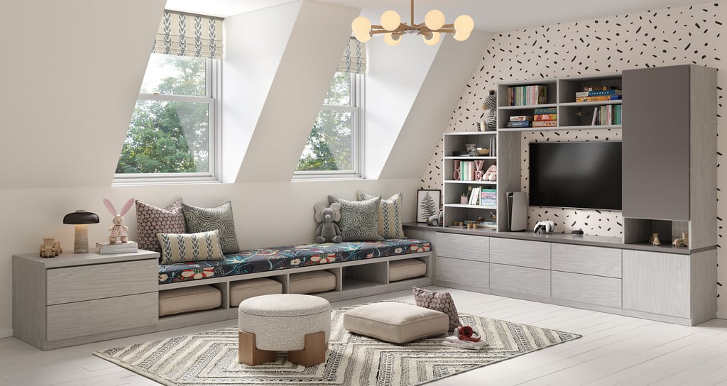 Playroom meets entertainment center wall with custom storage drawers, cubbies, open shelves and bench in light wood grain finish by California Closets
