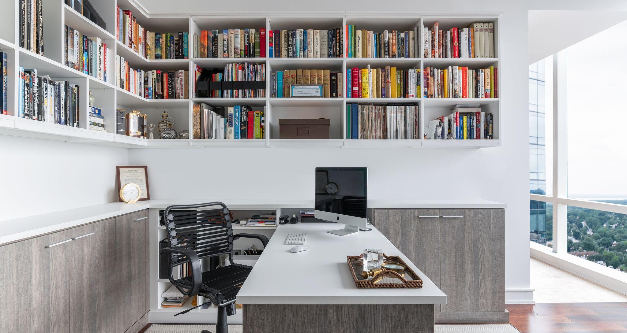 Home office with ceiling bookshelves and built-in desk by California Closets