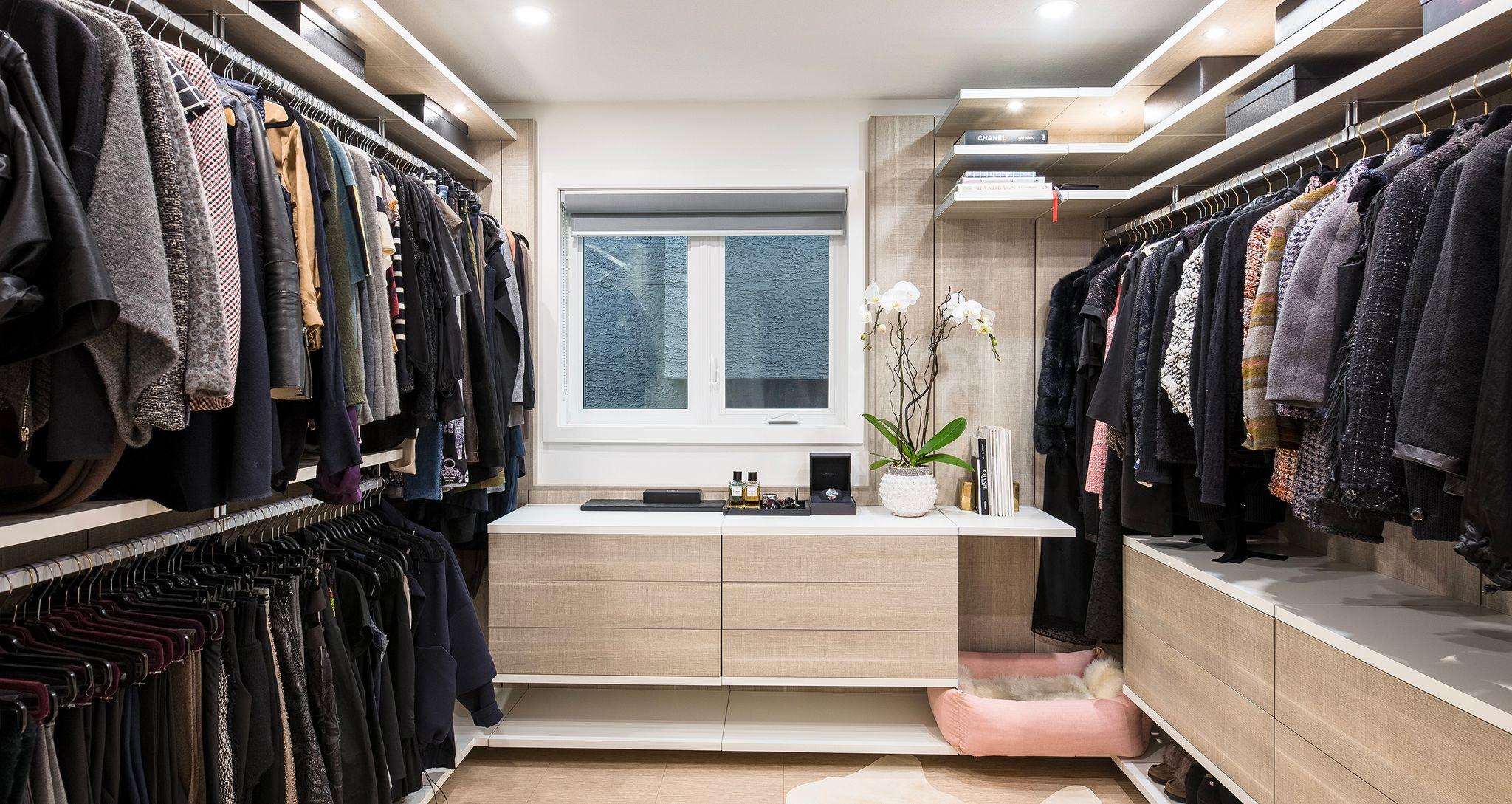 Upgraded walk in closet with floating cabinets and open shelves created for a Chanel buyer by California Closets