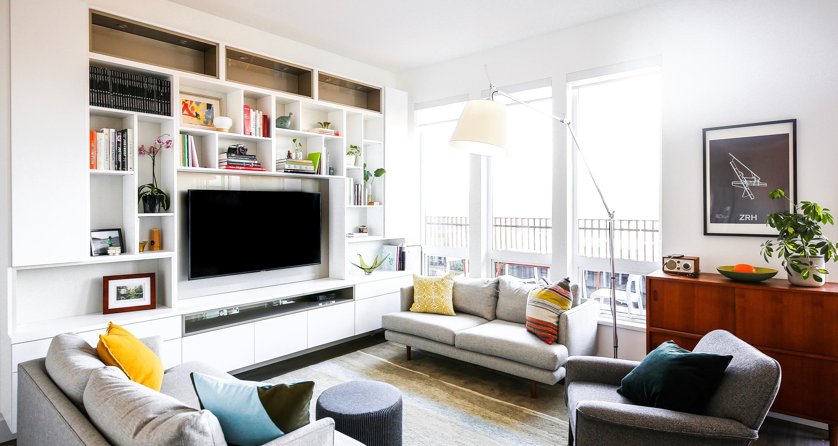 A custom media center in living room with surrounding built in shelves by California Closets