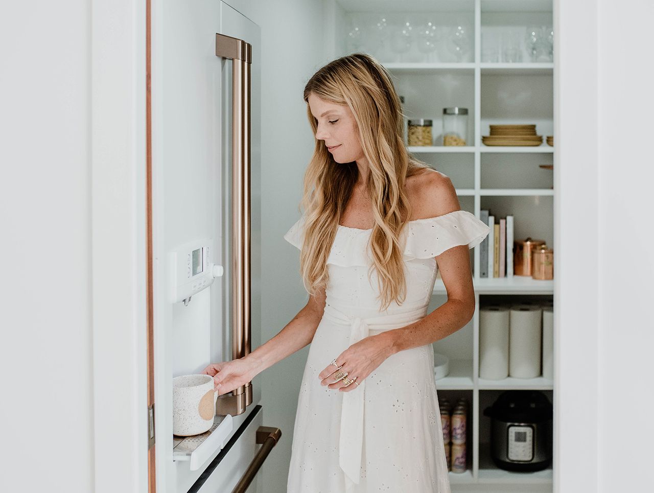 Sarah Sherman Samuel's kitchen pantry design with open shelving, pull out baskets and organizers in white finish by California Closets