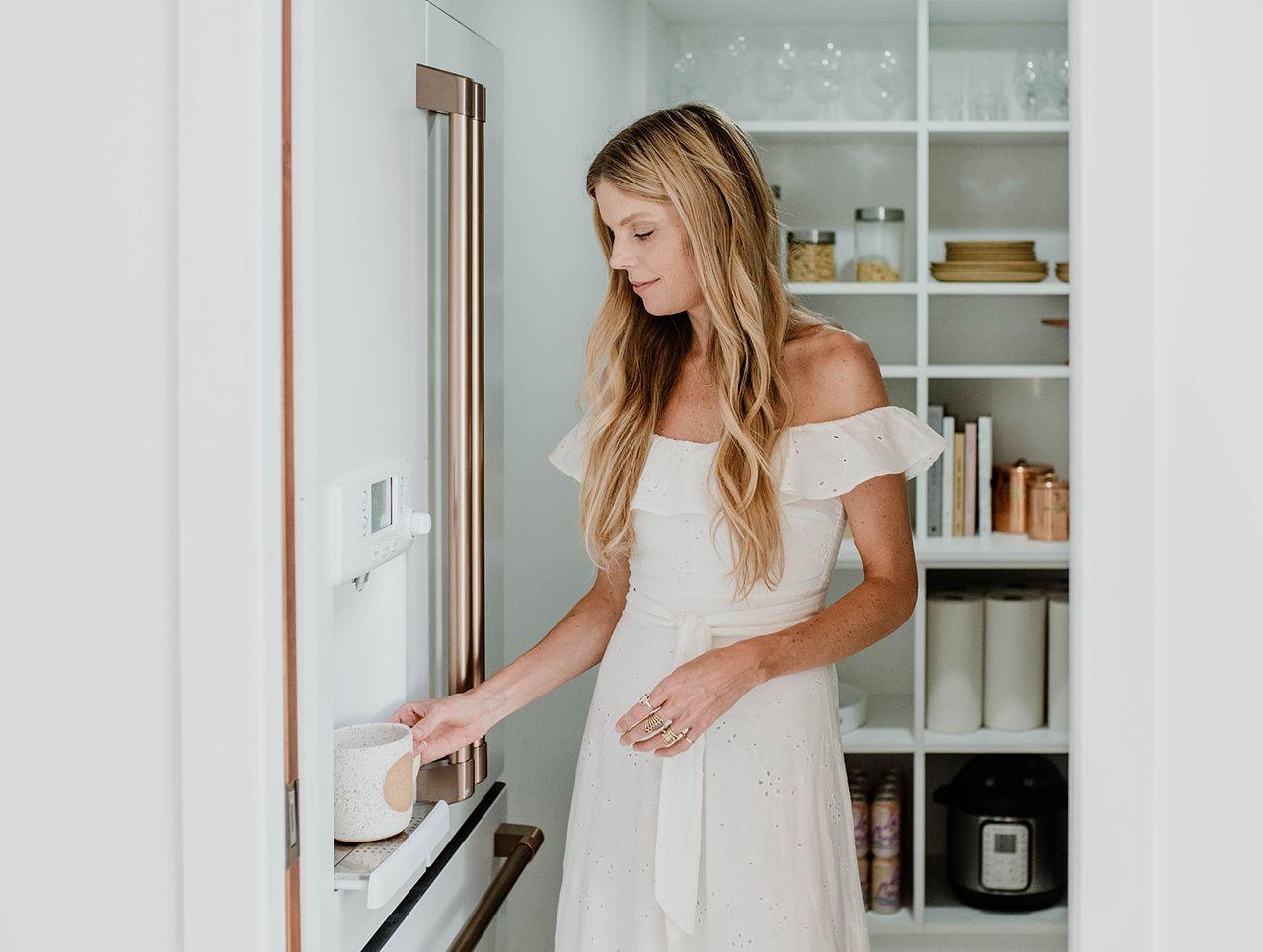 Diseño de despensa de cocina de Sarah Sherman Samuel con estantes abiertos, cestas extraíbles y organizadores en acabado blanco de California Closets