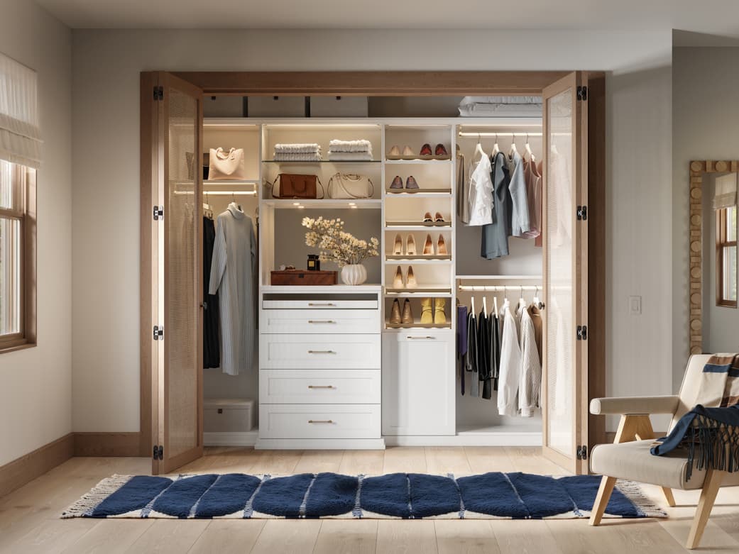 Personalized reach in closet, with white open shelving, customized LED lighting, long and short hanging wardrobe bars and closet organizers by California Closets