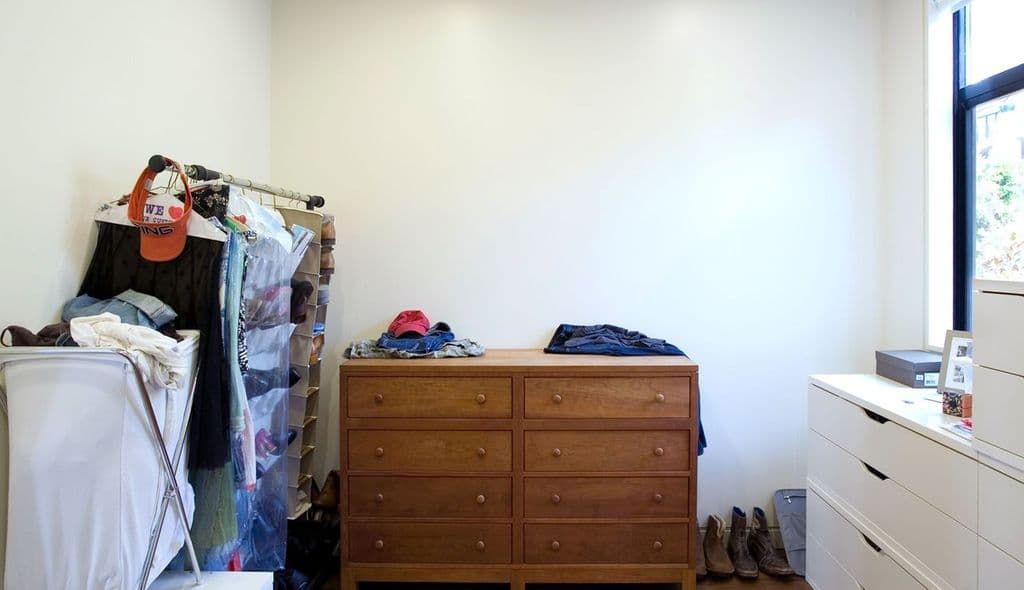 Imagen anterior del cliente de la habitación sin barras para colgar ni organizadores. California Closet completará el diseño e instalación.