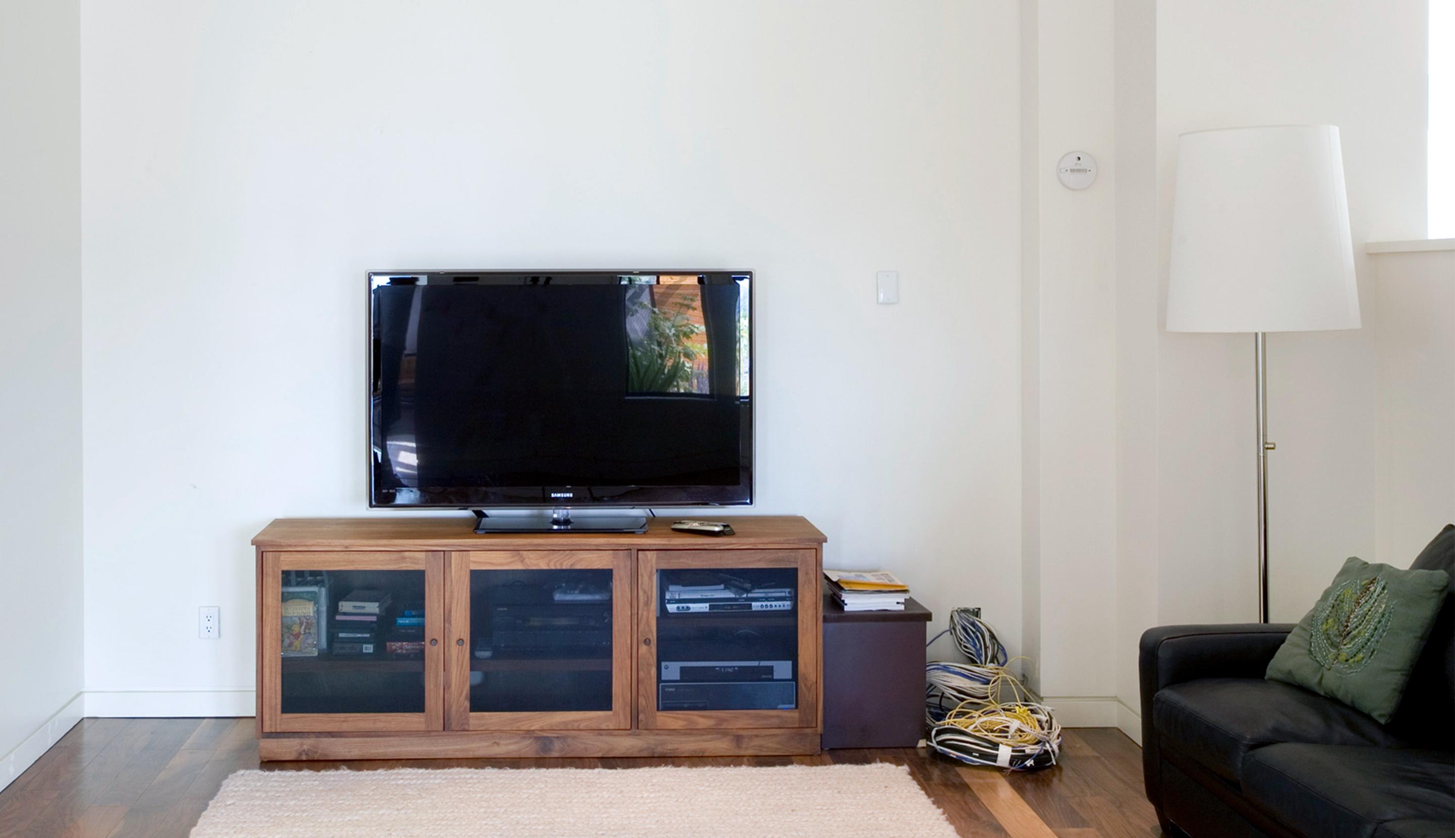 Before living space with no media storage and outdated entertainment center to be installed by California Closets