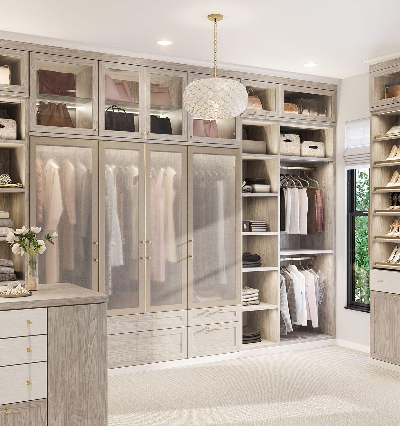 Walk in closet with shoe storage, pull-out accessory drawers, wardrobe glass doors in a light finish by California Closets