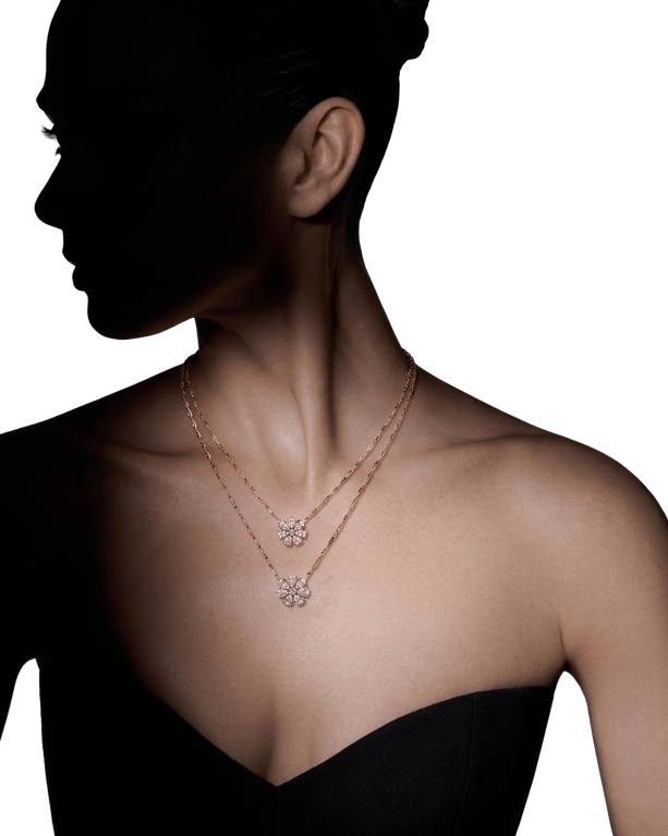 Two layered solitaire pendants on a fine rose-gold chain, worn at the throat