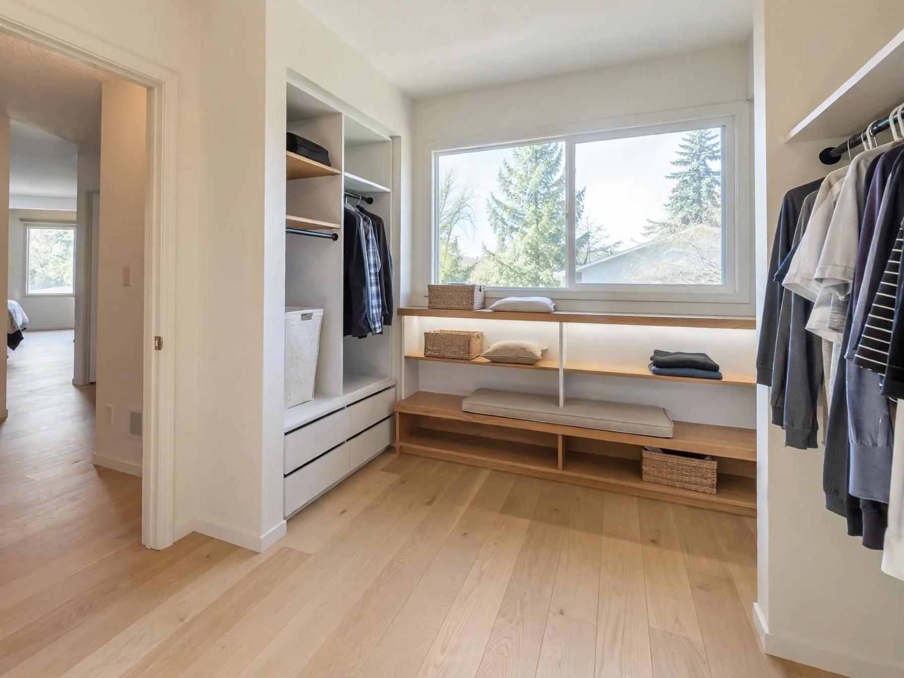 Minimalist walk in closet after AI restyle by Renovaitor: Bright fitted shelving and bench under the wide window