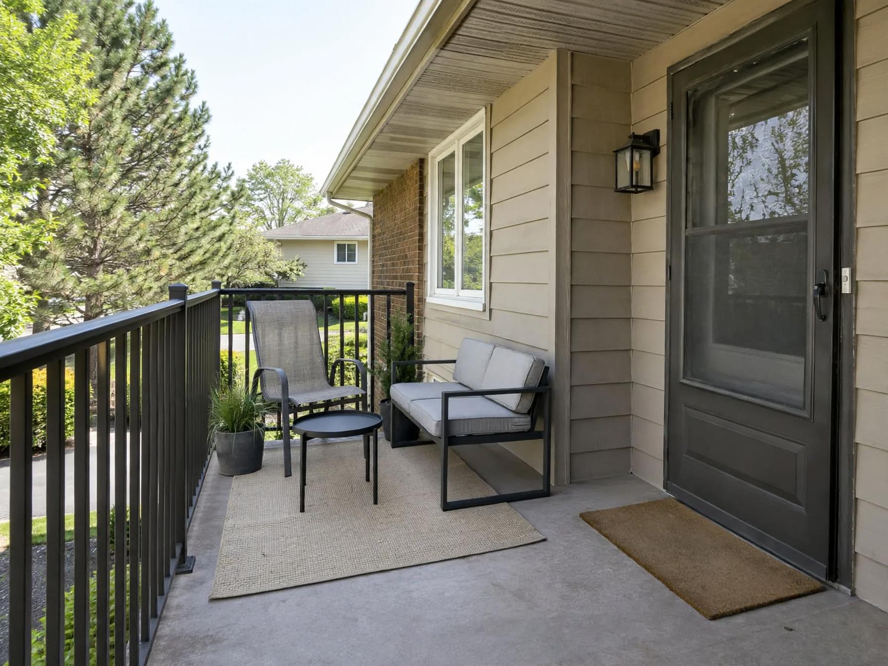 Minimalist outdoor after AI exterior redesign by Renovaitor: Black metal railing framed balcony with compact seating vignette