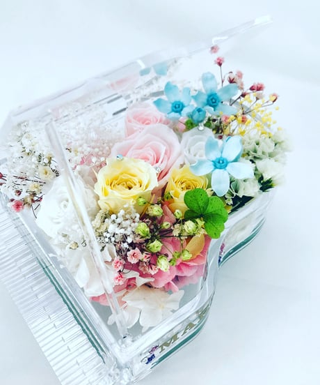 【プリザーブドフラワー／グランドピアノシリーズ】淡い色した花たちのピュアな輝きに四ツ葉のクローバーをそえて【フラワーケース付き】