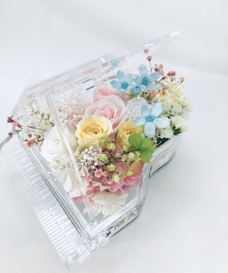 【プリザーブドフラワー／グランドピアノシリーズ】淡い色した花たちのピュアな輝きに四ツ葉のクローバーをそえて【フラワーケース付き】