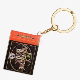 カールじいさんの空飛ぶ家』の王冠型ピンバッジとアドベンチャーブック