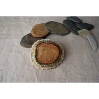 石を包み込んだ刺繍ブローチ
