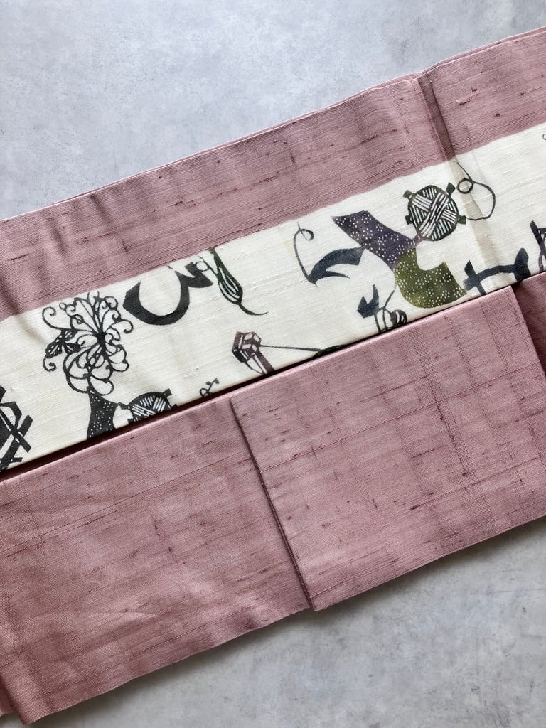 紬 名古屋帯 糸車文様 いろは文字 抽象柄 ピンク×生成り 正絹