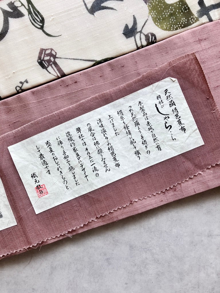 紬 名古屋帯 糸車文様 いろは文字 抽象柄 ピンク×生成り 正絹