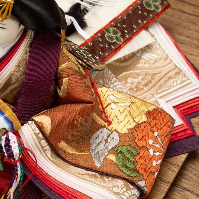 京十一番親王飾り「唐織袋帯：菊水に椿文錦」 | 桂雛／小佐畑人形店
