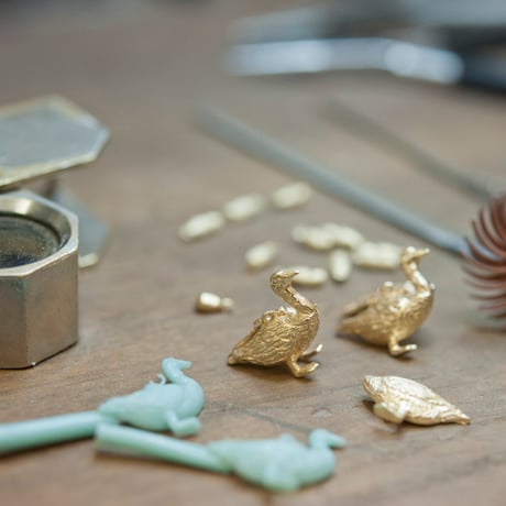 golden goose with an egg pendant