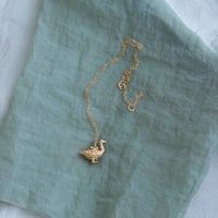 golden goose with an egg pendant