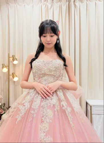 黒リボンが映える艶やかなストラップレスピンクドレス 艶やかな光沢感とゴールドラメの輝きが合わさったボリューム