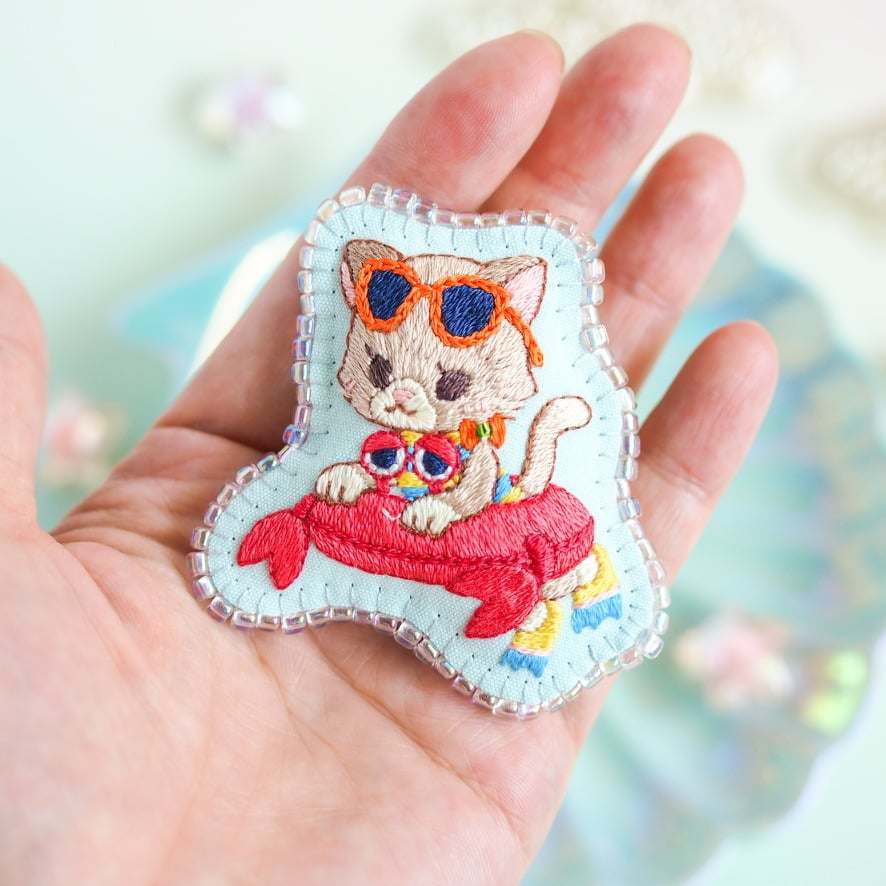 再販可能＊ふかふか刺繍スタイ＊おしゃぶりと♡＊ 刺繍ブローチ『カニの浮き輪でプカプカ猫さん』 | spica-pika