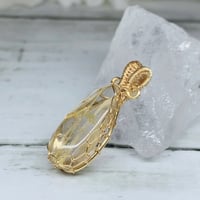 ［ペンダント］【ハイクォリティ】【キャッツアイ】高透明度タイチンルチル　ワイヤーペンダントトップ　ゴールドカラー　31.4×12.1mm
