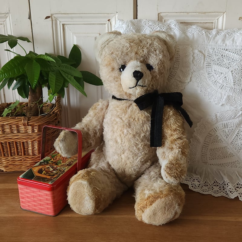 ベージュのリボン付きクマのぬいぐるみ