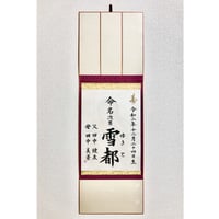 命名を半紙に書いて、裏打ちまたは色紙のように固く仕立て、簡易掛け軸に入れてお渡しします。