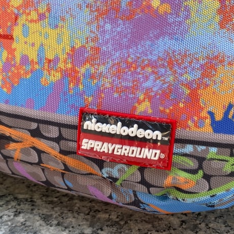 米国仕様 SPRAYGROUND ニコロデオン ラグラッツ RUGRATS ペイント シチュエーション バックパック (BKPK33)