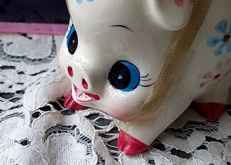 お花とリボンを付けた豚の貯金箱