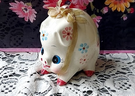 お花とリボンを付けた豚の貯金箱