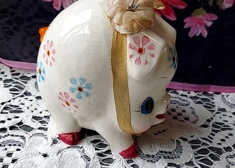 お花とリボンを付けた豚の貯金箱