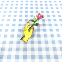 エナメルピン　バラの花を持つ手