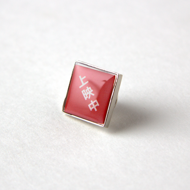 上映中」ピンバッチ（ケース入り） | 出町座 売店