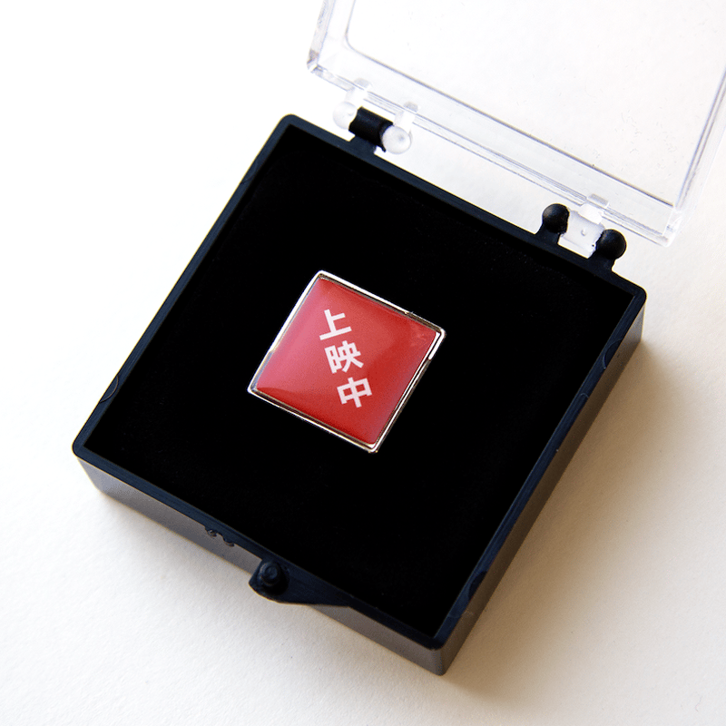 上映中」ピンバッチ（ケース入り） | 出町座 売店